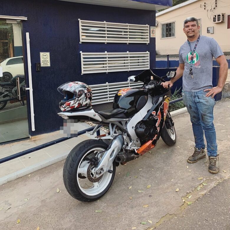 Cliente contemplado ao lado da motocicleta conquistada pelo consórcio