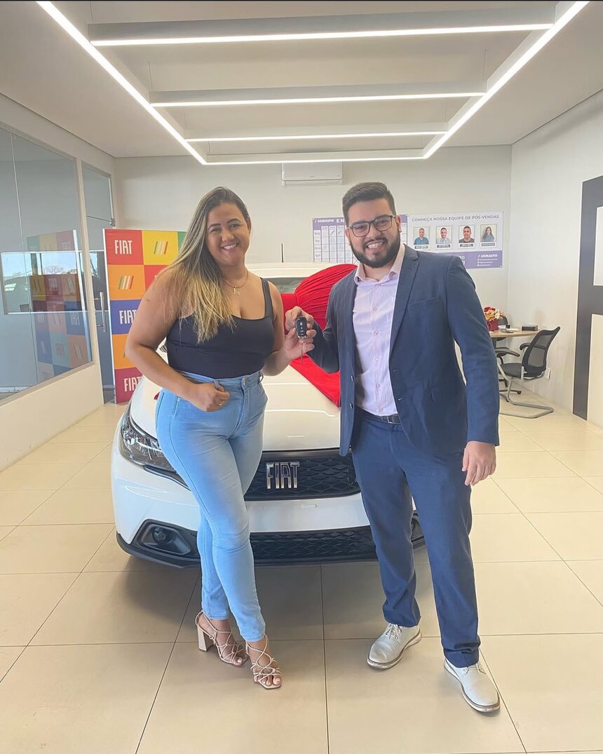 Cliente do Grupo Acro recebendo a chave do carro conquistado pelo consórcio